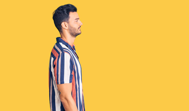 Young handsome hispanic man wearing casual  summer shirt looking to side, relax profile pose with natural face with confident smile.