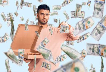 Young hispanic man holding delivery pizza box with angry face, negative sign showing dislike with...