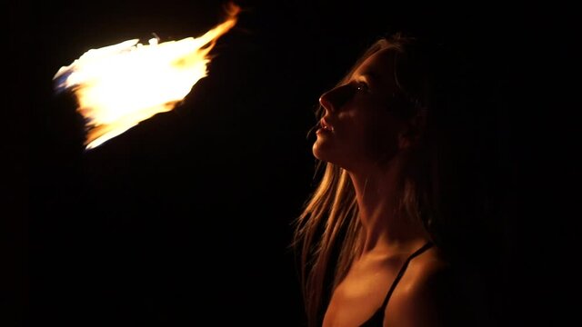 Woman spin fireball at night fire show