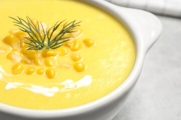 Delicious creamy corn soup in bowl on table, closeup