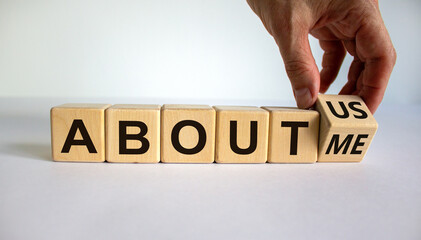 Hand turns a cube and changes the expression 'about me' to 'about us'. Beautiful white background....
