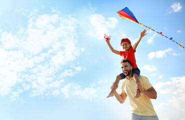 Happy father and his child playing with kite on sunny day. Spending time in nature - Powered by Adobe