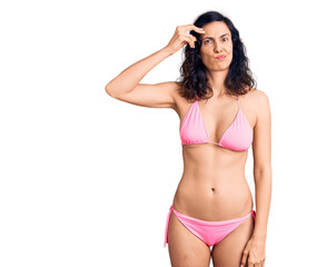 Obraz premium Young beautiful hispanic woman wearing bikini worried and stressed about a problem with hand on forehead, nervous and anxious for crisis