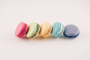 Multicolored macaroons sweets on the light background. Row of French macarons