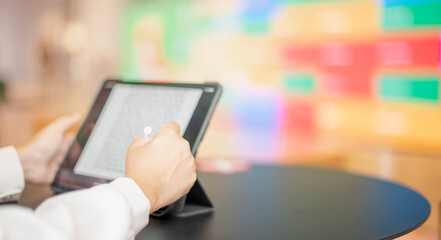 The female hand using digital tablet with pencil touch screen on desk work table at the co-working space.