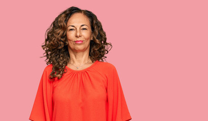 Middle age hispanic woman wearing casual clothes with serious expression on face. simple and...