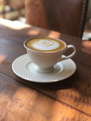 Hot cappuccino cup on table in coffee shop