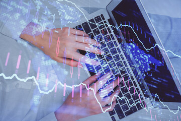 Double exposure of woman hands working on computer and forex chart hologram drawing. Top View. Financial analysis concept.