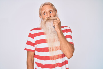 Old senior man with grey hair and long beard wearing striped tshirt serious face thinking about...