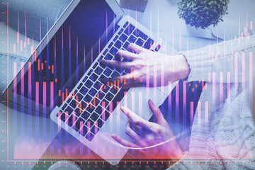Double exposure of woman hands working on computer and forex chart hologram drawing. Top View. Financial analysis concept.