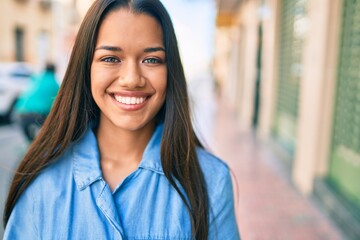 Obraz premium Young latin girl smiling happy walking at the city.