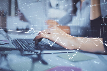 Multi exposure of woman hands typing on computer and financial graph hologram drawing. Stock market analysis concept.