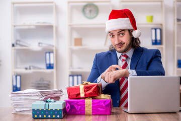 Young male employee working in the office at Christmas Eve
