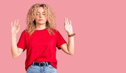 Young blonde woman with curly hair wearing casual red tshirt relaxed and smiling with eyes closed...