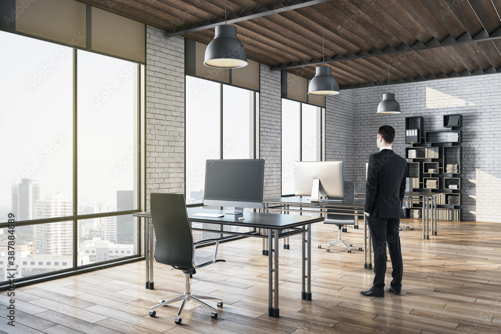 Poster Businessman standing in modern office with rows of computer tables