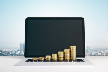 Growing chart of golden coins on laptop keyboard on city background.