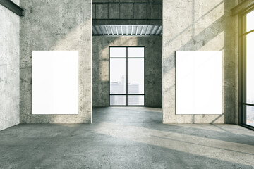 Simple interior with two blank poster on concrete wall.