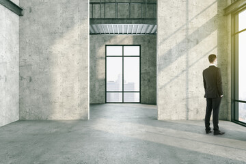 Businessman standing in modern concrete interior