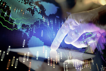 Double exposure of man's hands holding and using a digital device and forex graph drawing. Financial market concept.