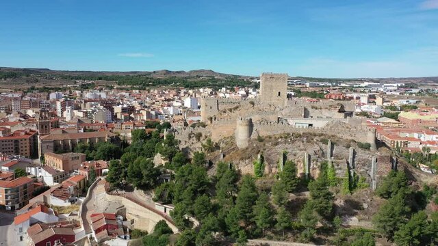 Aerial view of Almansa Castle, medieval fortification on stone hill surrounded by residential areas of city on sunny fall day, Albacete, Spain. High quality 4k footage