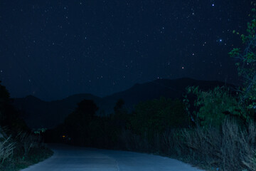 Fototapeta premium Night scene road mountains and stars from Palawan, Philippines, 2019 