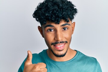 Young arab handsome man wearing casual clothes smiling happy and positive, thumb up doing excellent and approval sign