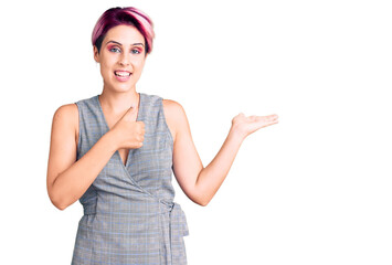 Young beautiful woman with pink hair wearing casual clothes showing palm hand and doing ok gesture with thumbs up, smiling happy and cheerful