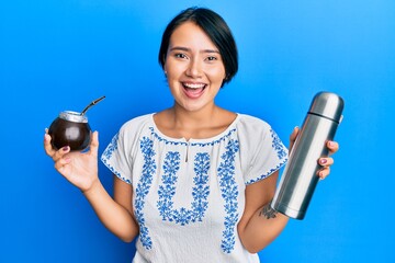 Beautiful young woman with short hair drinking mate infusion smiling and laughing hard out loud because funny crazy joke. © Krakenimages.com