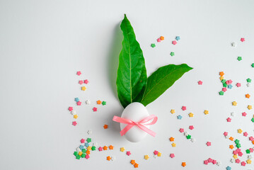 Happy Easter greeting card. Easter eggs with green leaves in the form of bunnies.