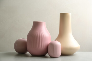 Stylish ceramic vases on grey stone table