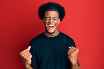 African american man with afro hair wearing casual clothes celebrating surprised and amazed for success with arms raised and eyes closed
