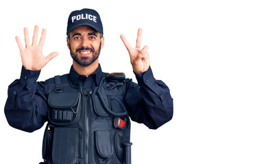 Young hispanic man wearing police uniform showing and pointing up with fingers number seven while smiling confident and happy.