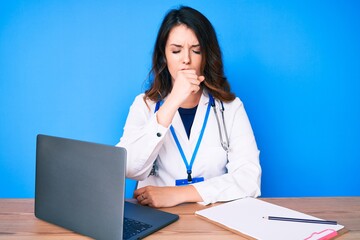 Young beautiful brunette woman wearing doctor uniform working at the clinic feeling unwell and coughing as symptom for cold or bronchitis. health care concept. - obrazy, fototapety, plakaty