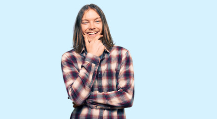 Handsome caucasian man with long hair wearing hipster shirt looking confident at the camera smiling with crossed arms and hand raised on chin. thinking positive.