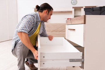 Young male carpenter repairing furniture at home