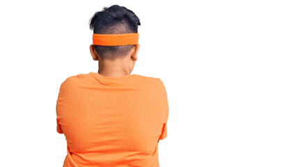 Little boy kid wearing sportswear standing backwards looking away with crossed arms