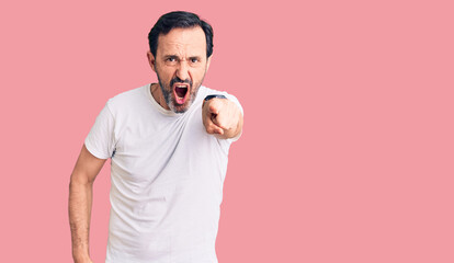 Middle age handsome man wearing casual t-shirt pointing displeased and frustrated to the camera, angry and furious with you