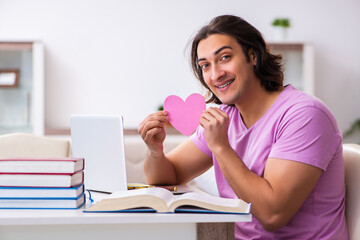 Male student in love preparing for exams at home