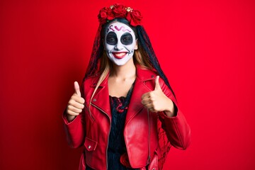 Woman wearing day of the dead costume over red success sign doing positive gesture with hand, thumbs up smiling and happy. cheerful expression and winner gesture.