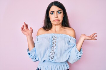 Brunette teenager girl wearing casual clothes clueless and confused with open arms, no idea and doubtful face.