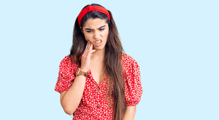 Brunette teenager girl wearing summer dress touching mouth with hand with painful expression because of toothache or dental illness on teeth. dentist