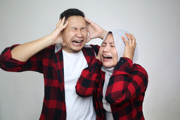 Funny Asian muslim couple, husband and wife crying together, sad hopeless expression