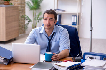 Obraz premium Young male employee suffering at workplace