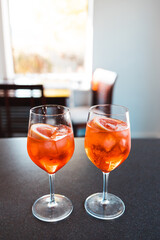 wine glasses with orange spritz cocktails on kitchen countertop