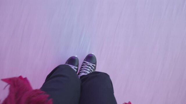 The guy is skating on an ice rink. Close-up of legs from above. POV - point of view. 4K size