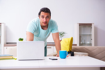 Young male parent looking after newborn at home