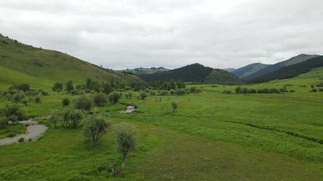 Landscape East Kazakhstan Upper Katon Karagay. Drone flight on DJI Mavic Air2, video 4K. River, green lowland near the mountains.
