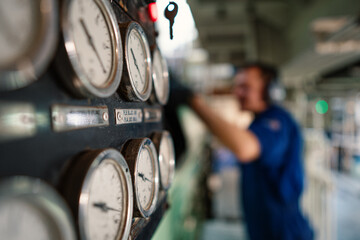 Marine engineer officer controlling vessel enginesand propulsion in engine control room ECR. Ship...