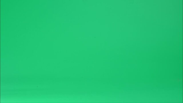 Stop Motion Animation, pile of books dropped on green background.