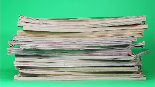 Stop Motion Animation, Large pile of books stacked together on green background.
